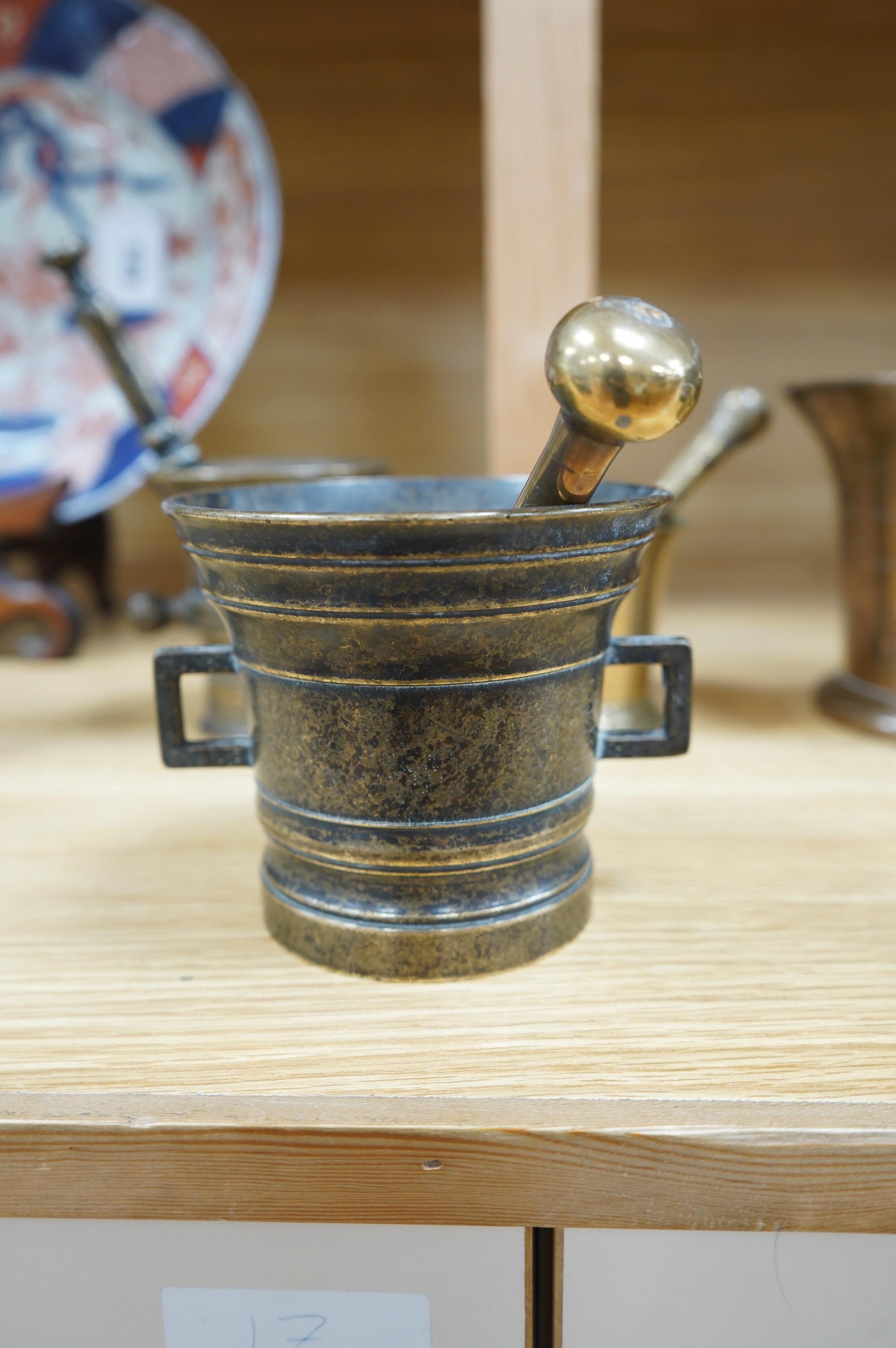 Four various bronze pestles and mortars and a small enamelled brass photograph frame, largest mortar 13cm high. Condition - fair